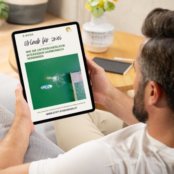 Mann der gerade das PDF "Urlaub für zwei" auf einem Tablet liest.